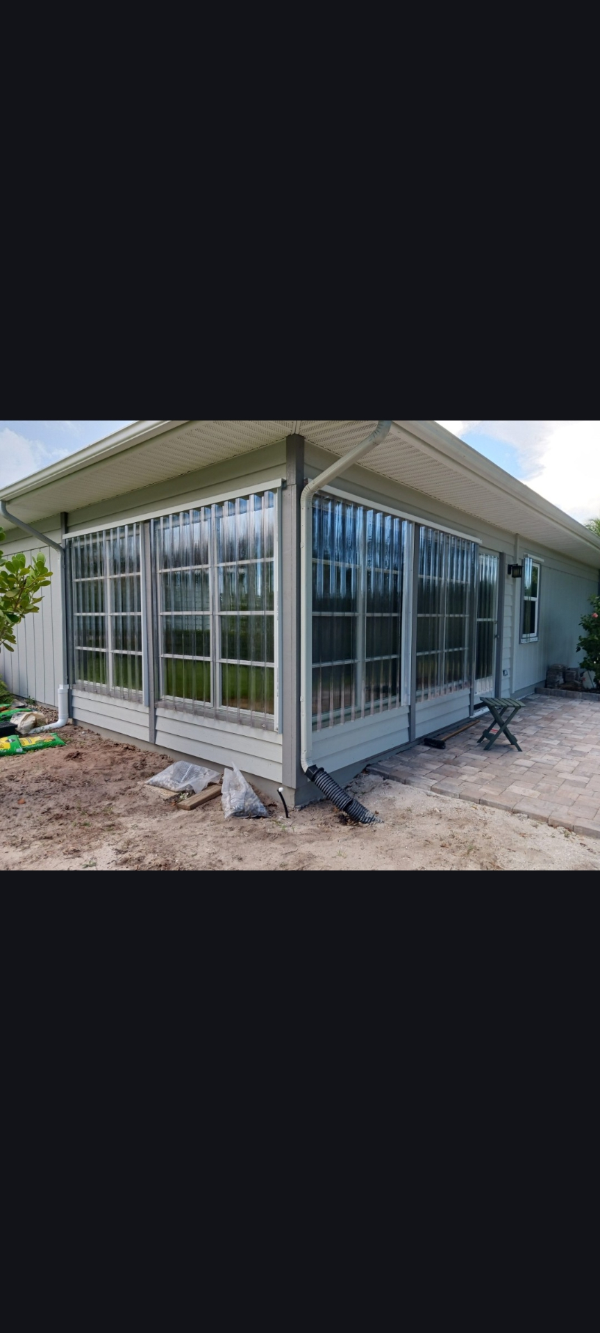 Home with hurricane panels installed before sunroom finish